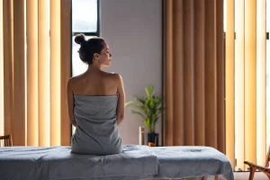 What Happens to Your Body After a Massage? - BeautifulWomanSittingontheMassageBedattheSpa